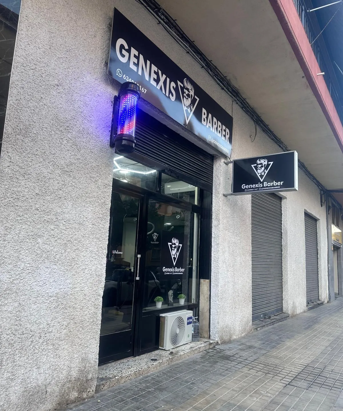 Fachada de Genexis Barber con el rótulo y la barra de barbero